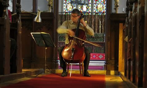 Musician Orlando Jopling playing the cello in a church