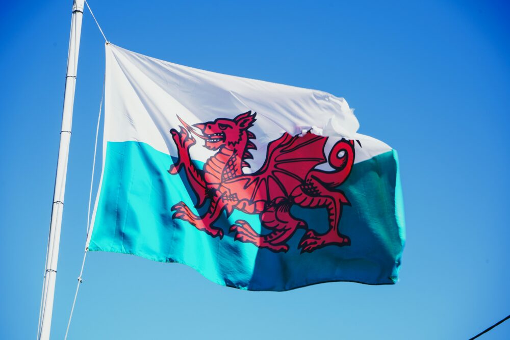 The Welsh flag on a white pole against a blue sky